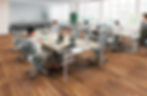 High-backed armchairs with built-in privacy screens, creating individual workspaces within an open office environment. Office furniture by Henricksen.