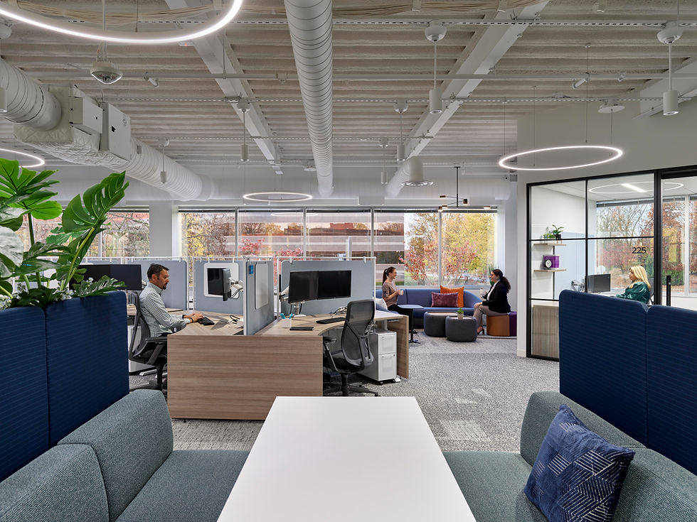 Modern office library or study area with bookshelves, a staircase, and built-in seating. Office design by Henricksen.