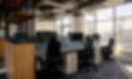 Modern open-plan office workspace with ergonomic chairs, individual workstations, and natural light. Office design by Henricksen.