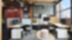Modern open-plan office workspace with individual workstations featuring ergonomic chairs and privacy screens.