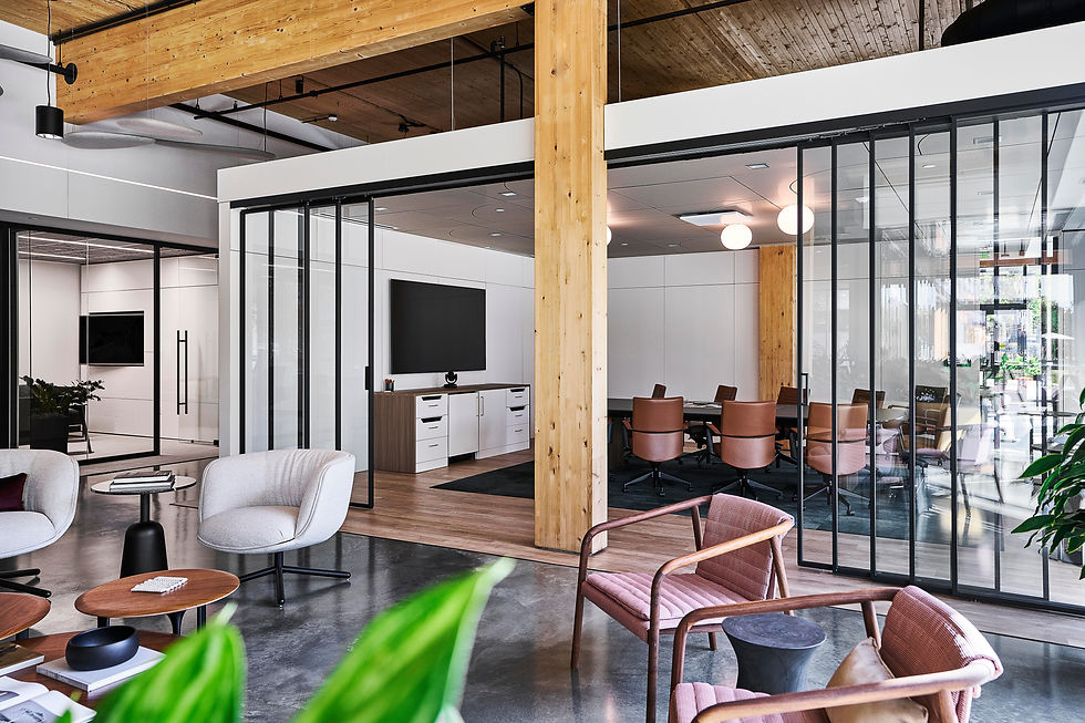 Contemporary conference room with glass walls, a large table with leather chairs, and a wall-mounted display screen.