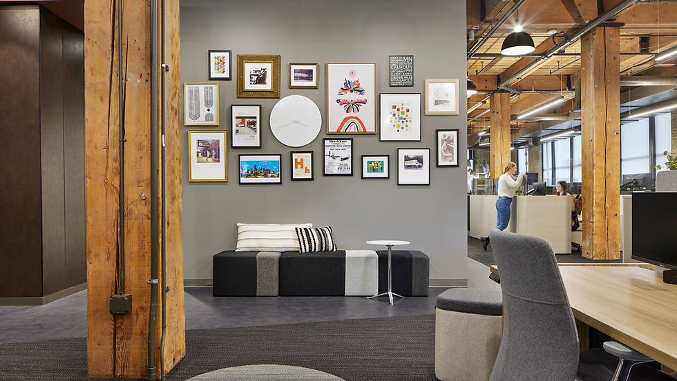 Modern office waiting area with a gallery wall and comfortable modular seating at Henricksen