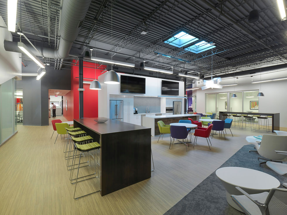 Modern office break room or kitchen area with a large island, comfortable seating, and a contemporary design. Office design by Henricksen.