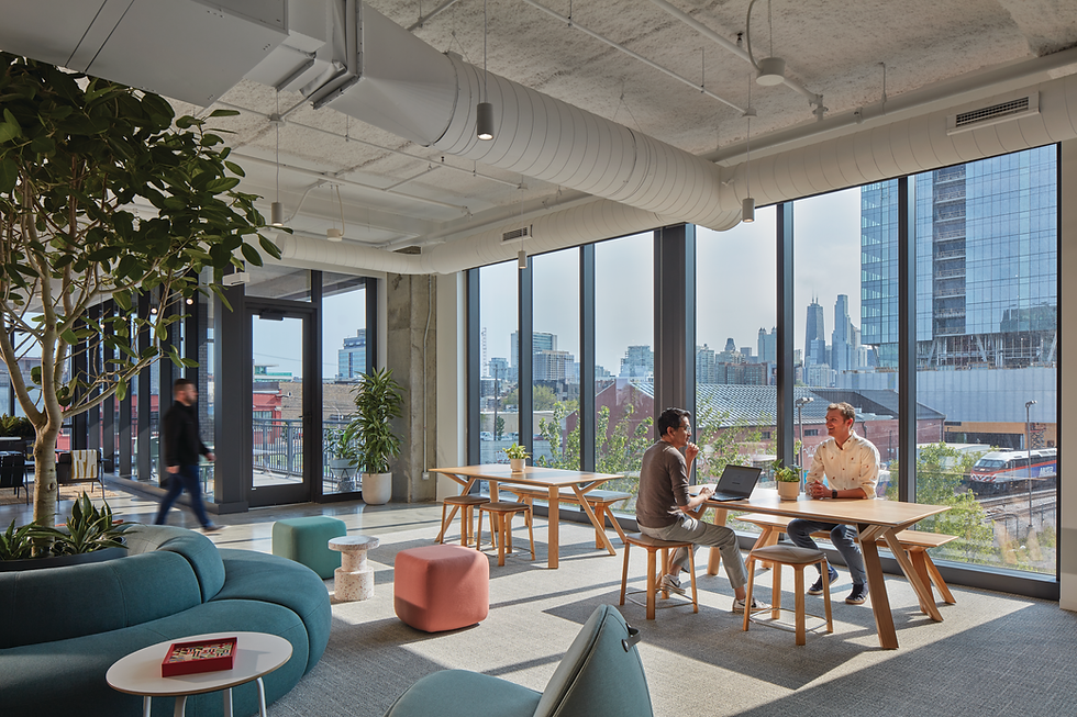People working together in a bright, open office with city views.