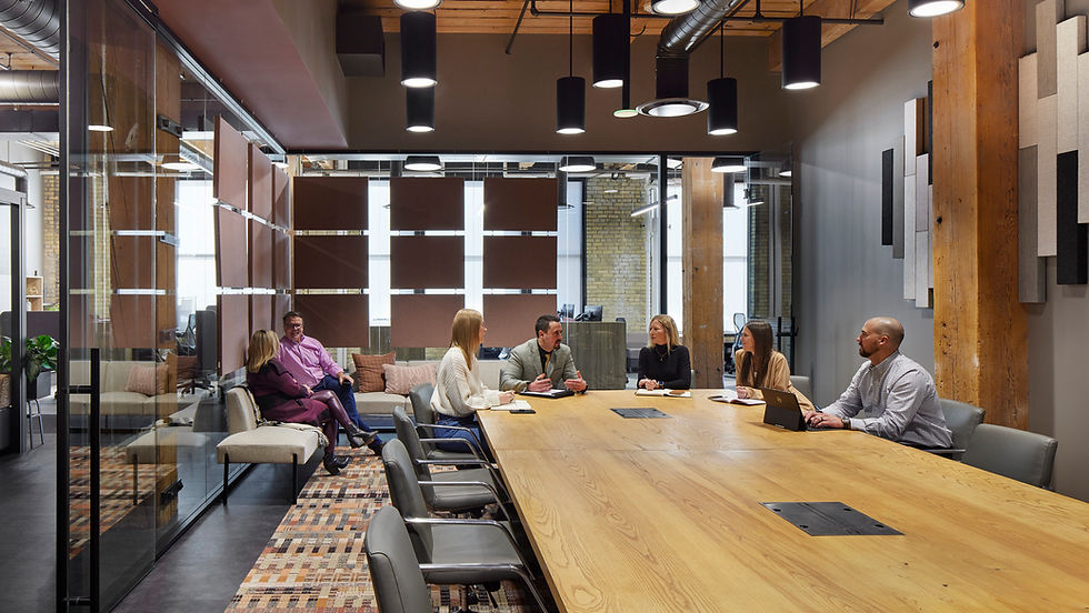Modern conference room with long table, chairs, and stylish lighting.