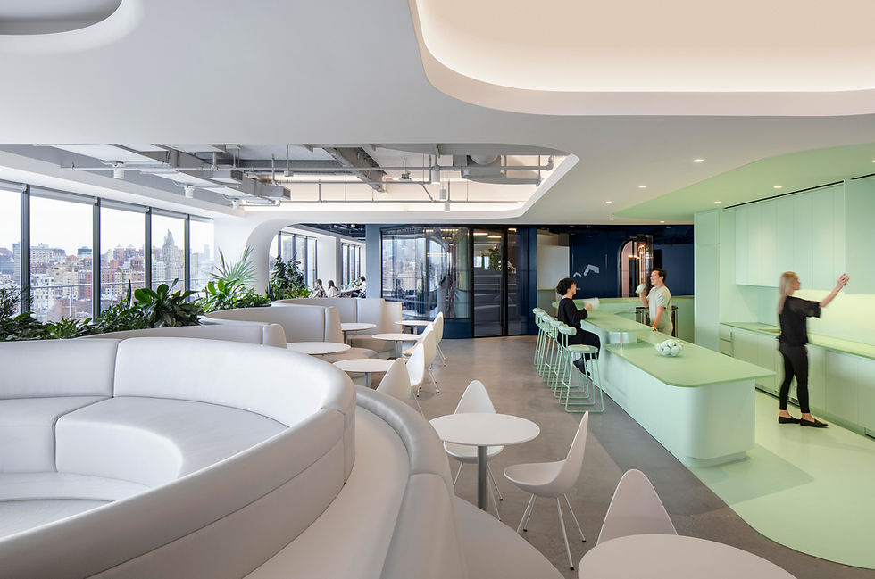 Modern office lounge and collaboration area featuring a curved sofa, tables, chairs, and a counter with bar stools. Office design by Henricksen.