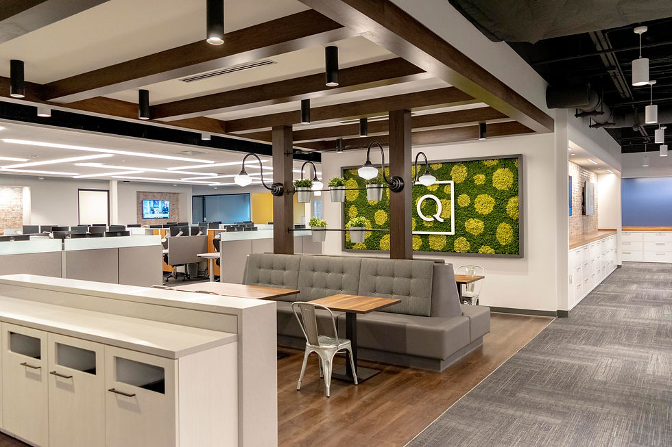 Modern office design featuring a mix of open workstations and a comfortable breakout area with booth seating. Office design by Henricksen.