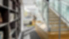 Modern office interior with exposed ductwork, glass-walled offices, and contemporary workstations.